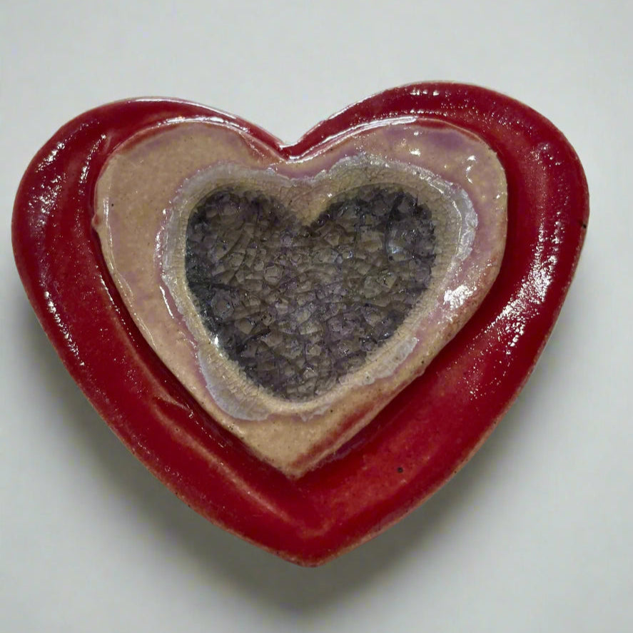 Handmade ceramic Heart shaped magnet in red and pink with purple glass inset 